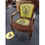 A carved walnut salon armchair in tapestry fabric