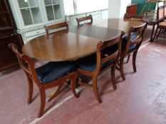 A Regency style mahogany and brass inlaid twin pedestal dining table and four chairs,