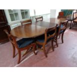 A Regency style mahogany and brass inlaid twin pedestal dining table and four chairs,