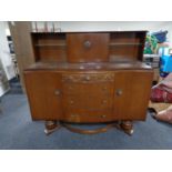 A mid century serpentine fronted oak buffet sideboard