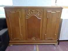 A twentieth century continental oak triple door sideboard on bun feet