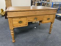 A pitch pine lift top writing desk fitted with three drawers