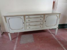 A twentieth century painted cream and gilt double door sideboard fitted with four drawers