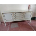 A twentieth century painted cream and gilt double door sideboard fitted with four drawers