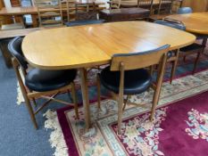 A mid century G-plan teak extending dining table together with a set of four G-plan teak chairs