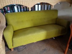 A mid century settee in light green fabric