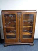 A twentieth century walnut double door display cabinet