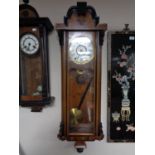 An early twentieth century walnut cased wall clock with brass and enamelled dial,
