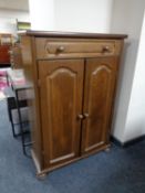 An oak double door cabinet fitted with a drawer on bun feet