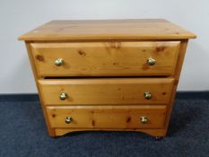 A pine three drawer chest with glass handles