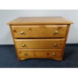 A pine three drawer chest with glass handles