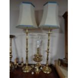A pair of brass rise and fall table lamps with shades together with a further pair of brass lamps