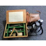A wooden box of optometrist items, two pairs of binoculars,