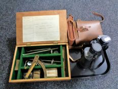 A wooden box of optometrist items, two pairs of binoculars,