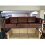 A mid century Danish brown leather three seater settee