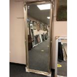 A silver framed floor standing mirror