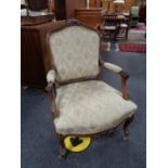 A walnut framed French armchair upholstered in floral fabric