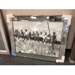 A mirrored framed picture of workmen
