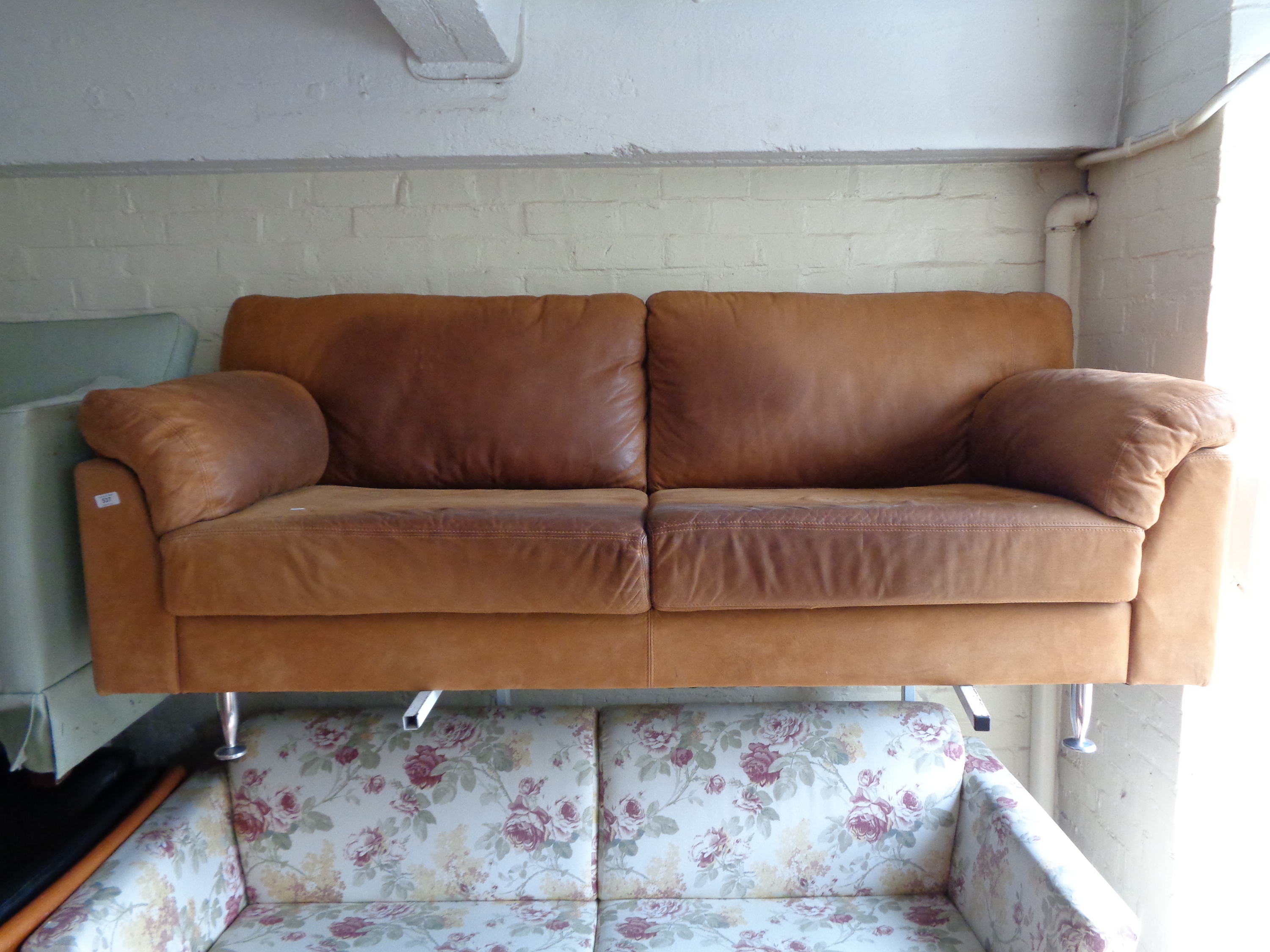 A tan leather three seater settee.