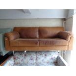 A tan leather three seater settee.