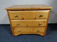 A pine three drawer chest with glass handles