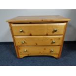 A pine three drawer chest with glass handles