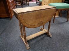 A twentieth century carved oak drop leaf occasional table