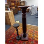 An early twentieth century mahogany torchere together with one other plant stand