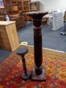 An early twentieth century mahogany torchere together with one other plant stand