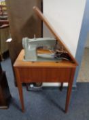 A Singer electric sewing machine in teak table