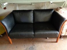 A twentieth century Danish stained beech framed two seater black leather settee