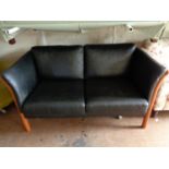 A twentieth century Danish stained beech framed two seater black leather settee