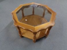 An octagonal glass topped two tier coffee table