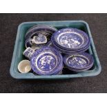 A plastic crate of blue and white willow pattern china