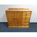 A pine double door sideboard fitted with four drawers