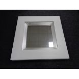 A white contemporary framed mirror CONDITION REPORT: This is 89cm by 89cm by 7.
