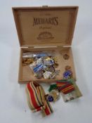 A wooden cigar box containing WW II medals,