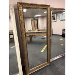A gold ornate framed mirror