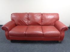 A Barker & Stonehouse three seater scroll arm settee in red leather