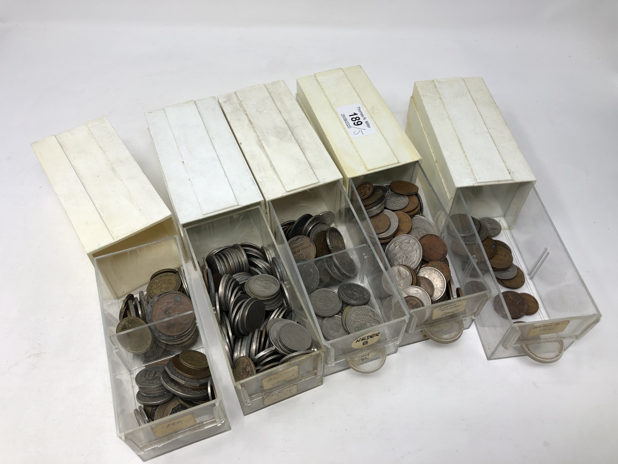 Five small containers of world coins,