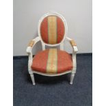 A white salon armchair in striped fabric