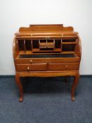 An Eastern mahogany barrel fronted bureau with brass inlay