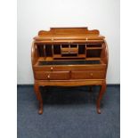 An Eastern mahogany barrel fronted bureau with brass inlay