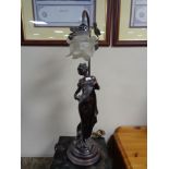 A contemporary figural table lamp of a female figure with glass shade