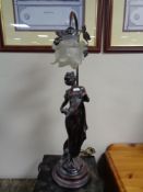 A contemporary figural table lamp of a female figure with glass shade