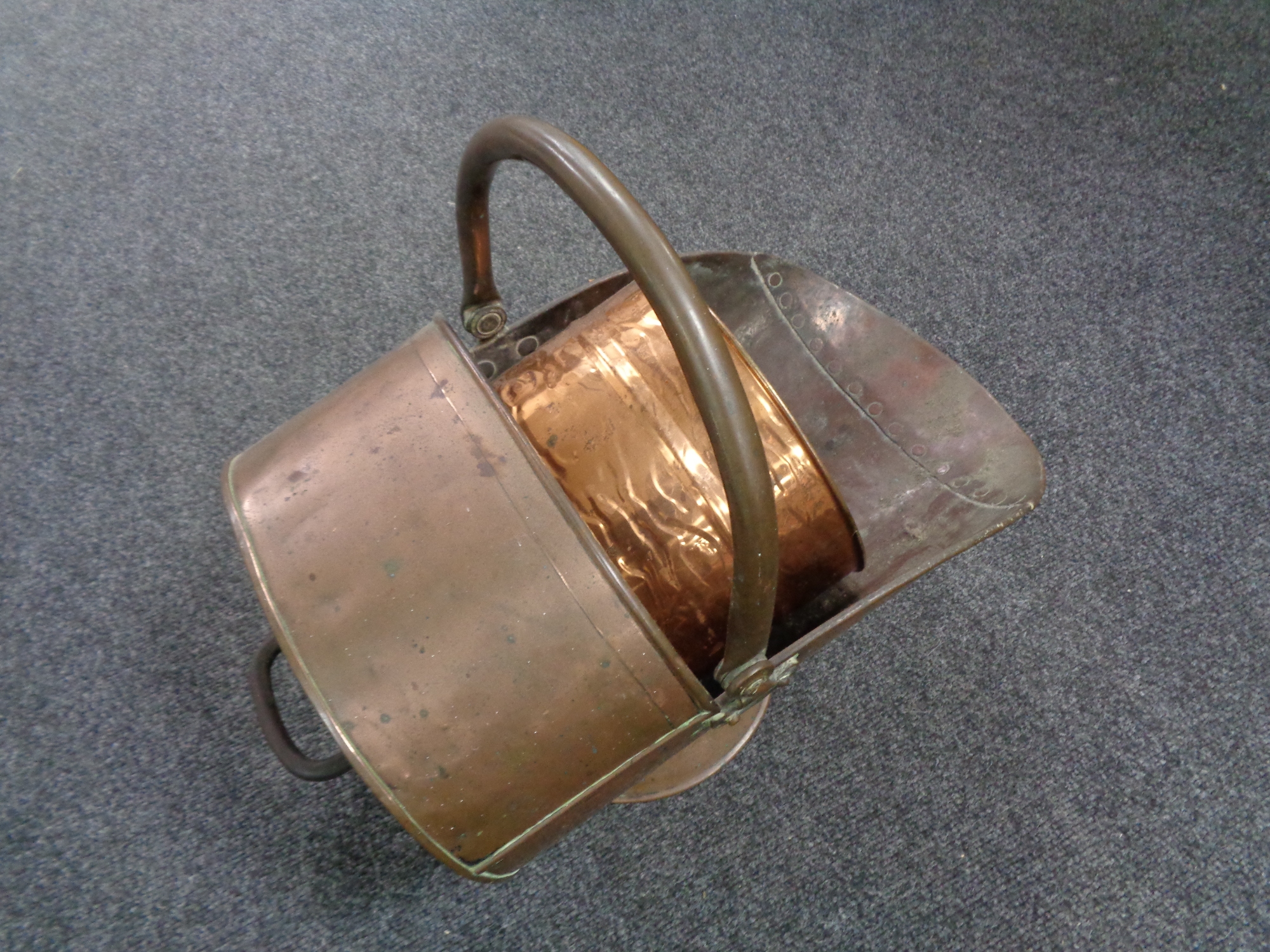 An antique copper coal helmet together with a brass bucket