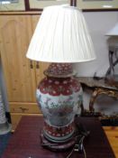 A Chinese table lamp on wooden stand