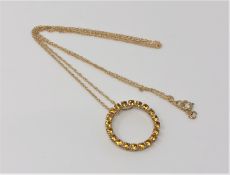 A gold citrine circular pendant on chain