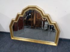 A shaped gilt framed overmantel mirror width 116 cm x 85 cm height.