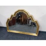 A shaped gilt framed overmantel mirror width 116 cm x 85 cm height.